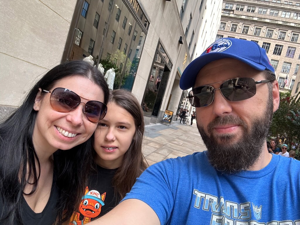 A photo of the Angrisano family standing in front of some buildings in New York City